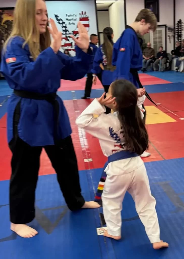 A student practicing a kick with a coach
