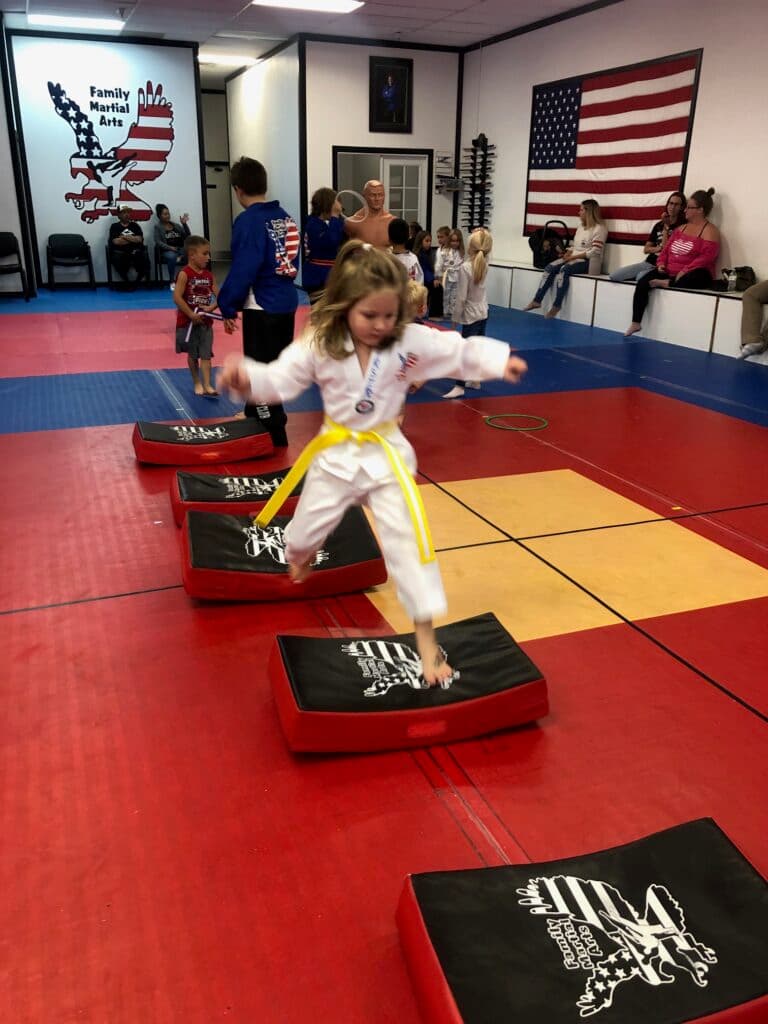Little Dragons students kicking pads with a coach